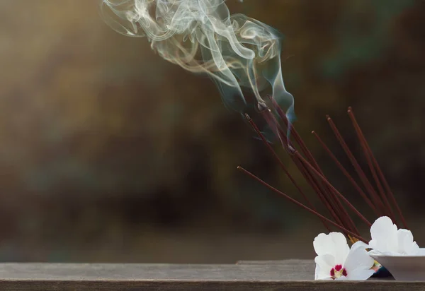 Many incense sticks were lit to perform Buddhist rituals Smoke from large quantities of incense and white flowers for Buddhist rituals, religious ceremonies in the open air. Copy space.