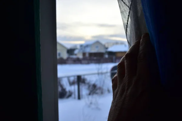 Eller pencerenin perdelerini çeker.