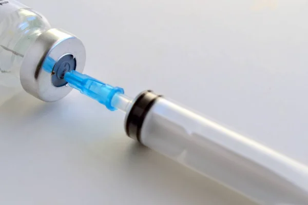syringe with a needle and a bottle of medicine