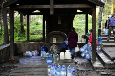 people collect water from an underground source near the village of Antsifirovo, Moscow region, Russia