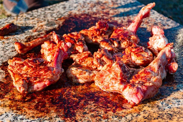meat of young lamb on the bone is fried on marble slab. Picnic in nature. delicious juicy grilled lamb meat. kitchen in nature. selective focus.