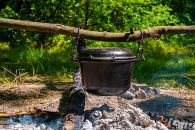 Şöminenin üstünde melon şapka. Yakacak odun tutuşturucu ve duman çıkarıyor. Ateşin son dilleri. Bovling sopanın kablo tutacağı tarafından askıya alındı.