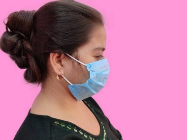 Beyaz arka planda tıbbi maske takan genç Hintli kadın yüzü. Sağlığınızı koruyun. Coronavirus konsepti