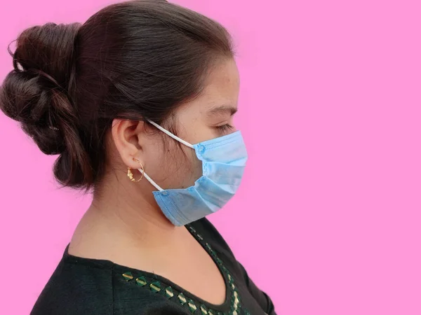 Seitenansicht der jungen indischen Frau Gesicht trägt medizinische Gesichtsmaske auf weißem Hintergrund. Schützen Sie Ihre Gesundheit. Coronavirus-Konzept — Stockfoto