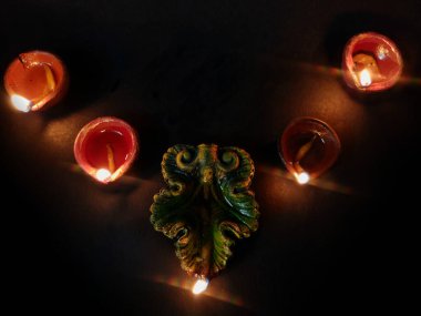 Yağ lambası ya da diya kullanılarak ev dekorasyonu Diwali kutlamaları için sıralanmış, derin, siyah arkaplan üzerine seçici bir odaklanma