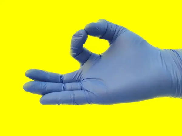 Human single Hand with gloves isolated on yellow background forming yoga poses , — Stock Photo, Image