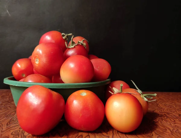 Frische Tomate im Teller mit schwarzem Hintergrund, selektiver Fokus mit Kopierraum — Stockfoto