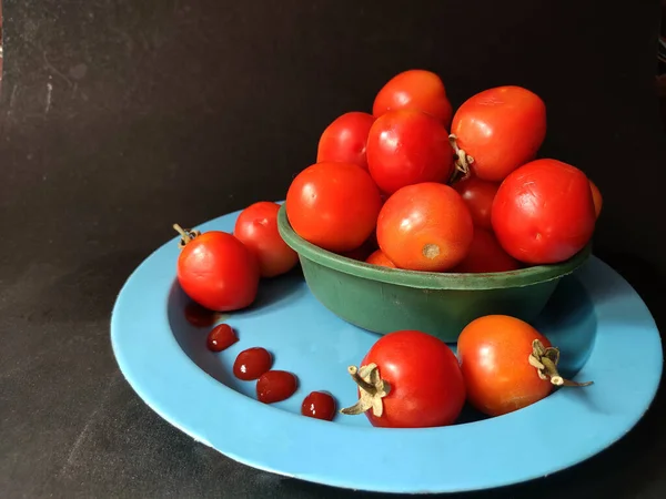 잘 익은 붉은 토마토로 만든 토마토 소스는 검은 색 바탕에 놓인 접시에 보관되어 있다 — 스톡 사진