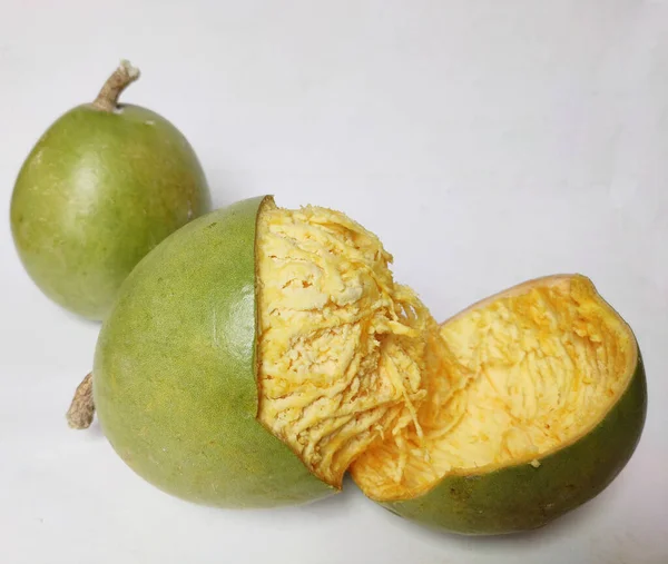 Wood Apple atau Aegle Marmelos adalah sebuah India. buah tropis benua dengan penutup keras dan bubur lembut pada latar belakang putih — Stok Foto