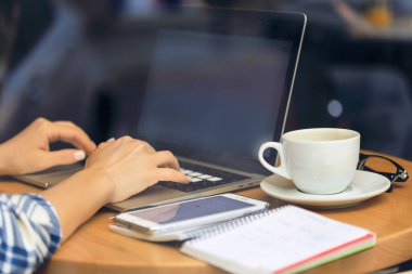 Female hands typing on pc. Unrecognizable women Working In A Cafe. Freelance work. Girl browsing the internet, chatting, blogging.
