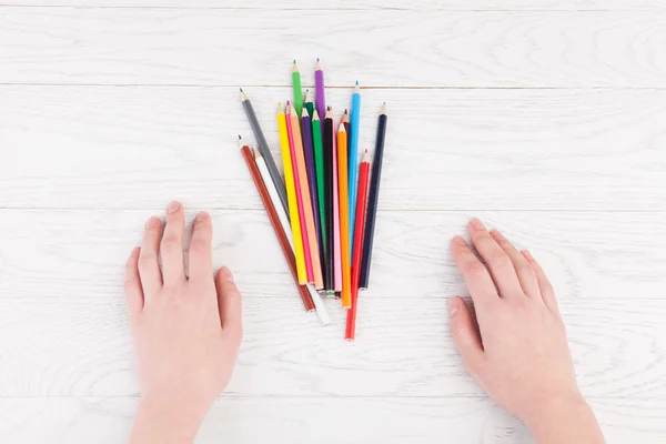 Vrouw handen en kleur potloden op tafel — Stockfoto