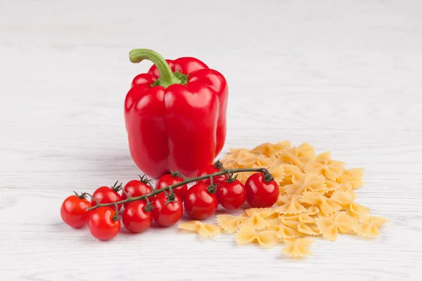 Tomates, poivrons rouges et macaronis sur la table — Photo