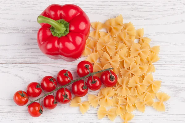 Tomates, poivrons rouges et macaronis sur la table — Photo