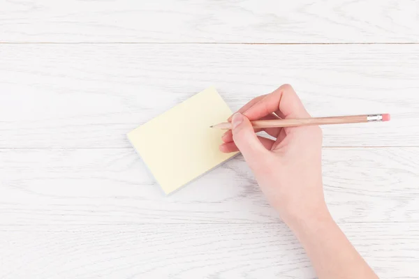 Χέρι γράφοντας στις σημειώσεις υπενθύμιση με ξύλινο μολύβι — Φωτογραφία Αρχείου