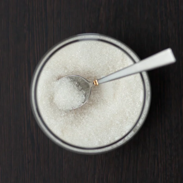 Glass jar with sugar and spoon — Stock Photo, Image