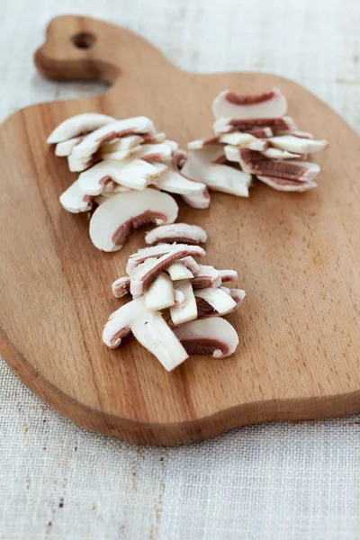 Champiñones botón blanco en una tabla de cortar de madera — Foto de Stock