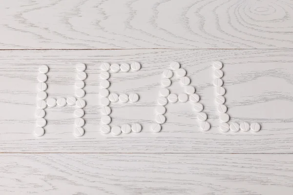 Word heal made of pills on table — Stock Photo, Image