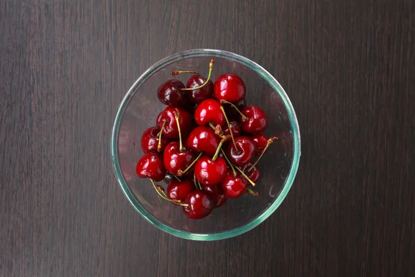 Świeże wiśnie w misce na stole — Zdjęcie stockowe