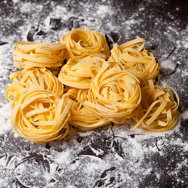 Macarrão cru tagliatelle na mesa — Fotografia de Stock