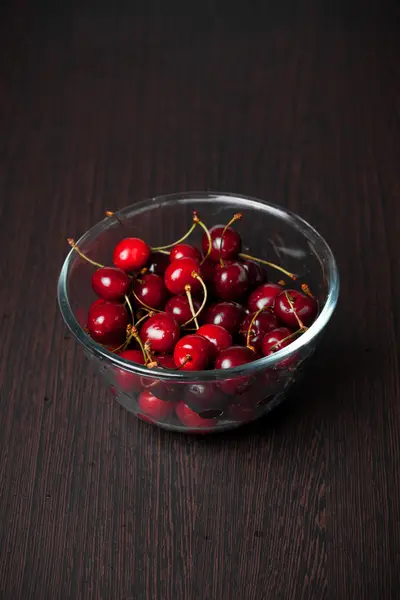 Frische Kirschen in einer Schüssel auf dem Tisch — Stockfoto