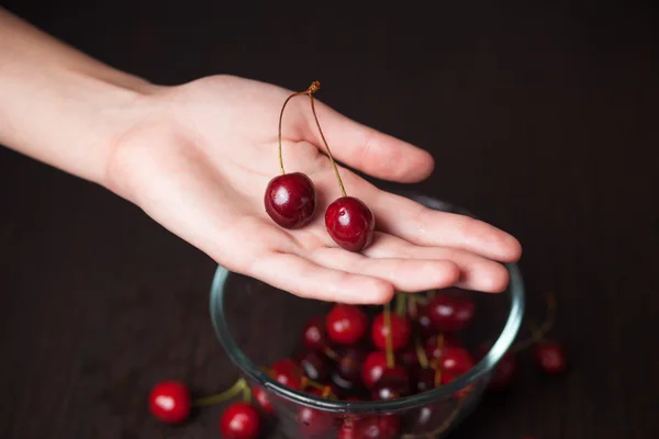 Cerejas frescas em mãos de mulher — Fotografia de Stock