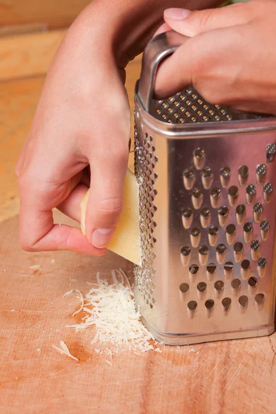 Cooking, food and home concept - close up of female hands gratin — Stock Photo, Image