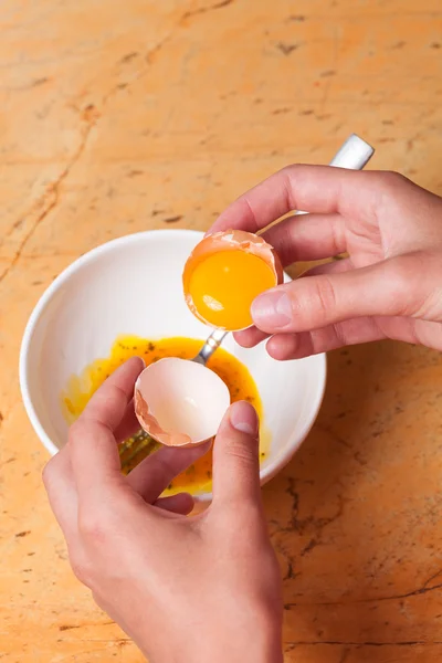 Hands breaking an egg in bowl — Stock Photo, Image