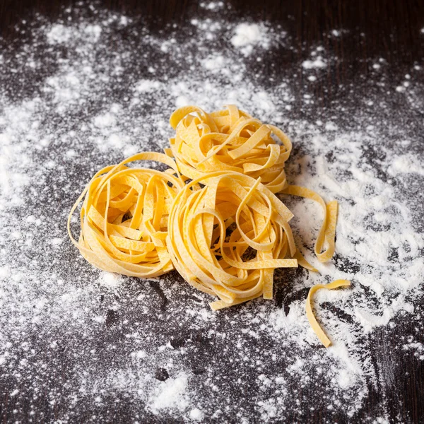 Tagliatelle di pasta cruda in tavola — Foto Stock