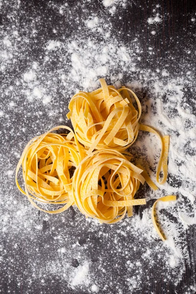 Сырая макароны tagliatelle на столе — стоковое фото