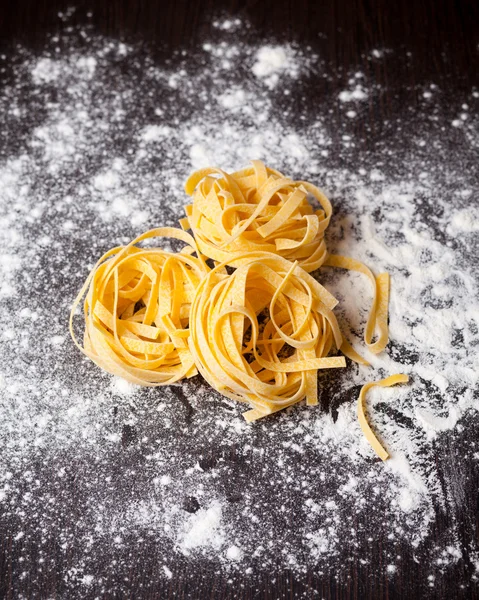 Macarrão cru tagliatelle na mesa — Fotografia de Stock