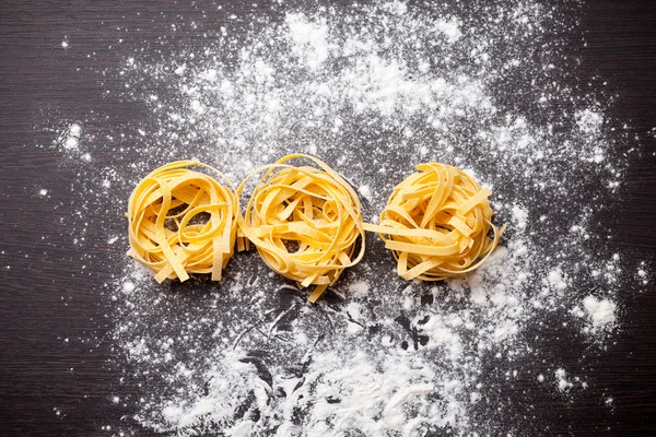 Macarrão cru tagliatelle na mesa — Fotografia de Stock