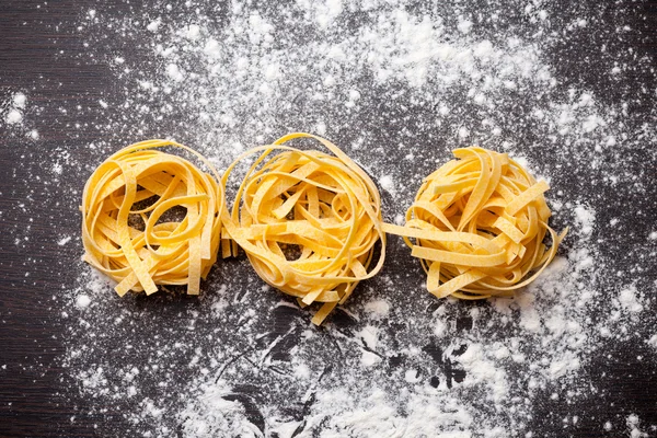 Macarrão cru tagliatelle na mesa — Fotografia de Stock