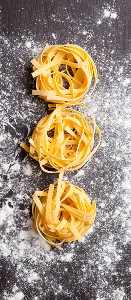 Macarrão cru tagliatelle na mesa — Fotografia de Stock