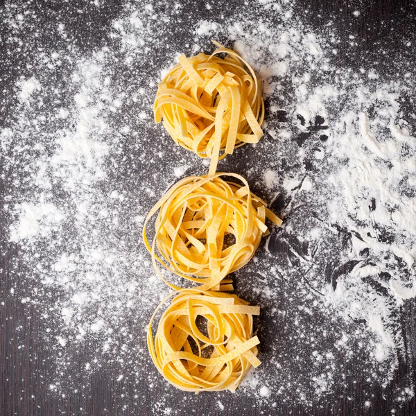 Macarrão cru tagliatelle na mesa — Fotografia de Stock