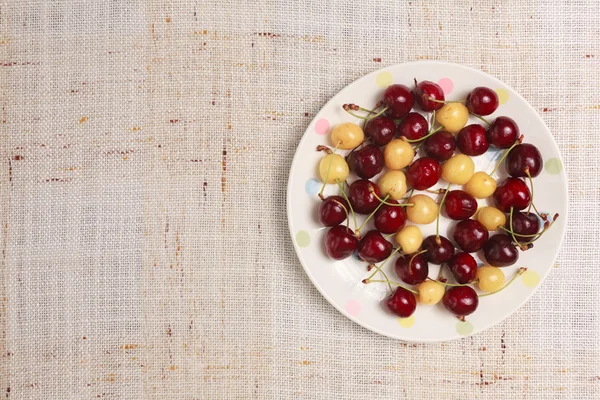 Cerises rouges et jaunes fraîches dans un bol — Photo