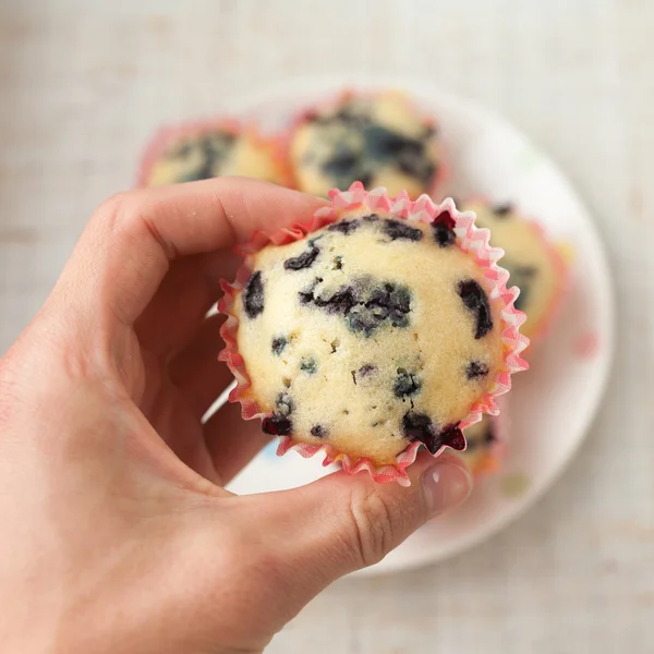 Hand met bosbessen muffin — Stockfoto