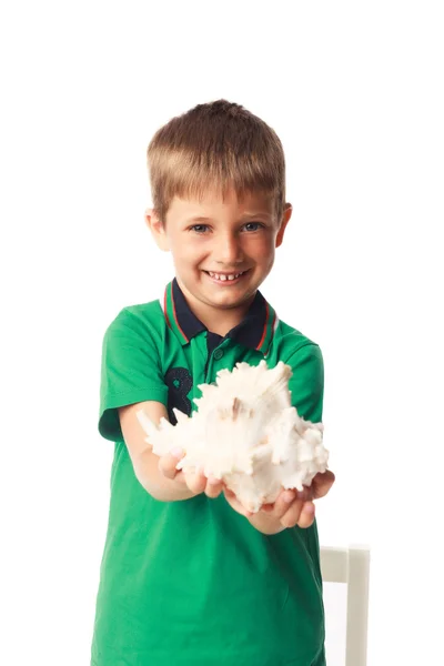 Маленький мальчик держит большую оболочку, изолированную на белом — стоковое фото