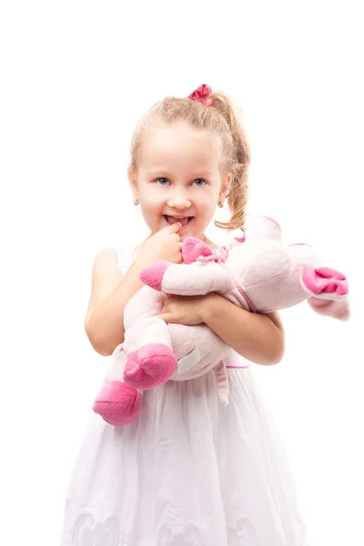 Linda niña sostiene juguete cerdo aislado —  Fotos de Stock