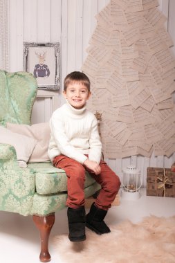 Küçük boy gülümseyerek sandalyede Noel iç