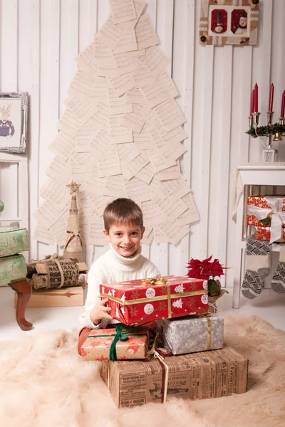 Kleiner Junge hält Geschenkbox im Weihnachtsinterieur — Stockfoto