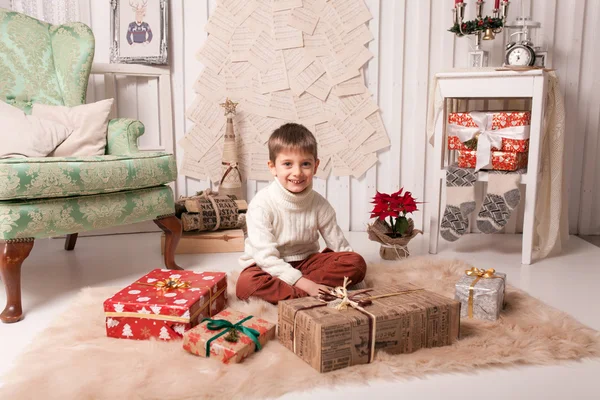 Little boy holding present box in Christmas interior — Stock Photo, Image