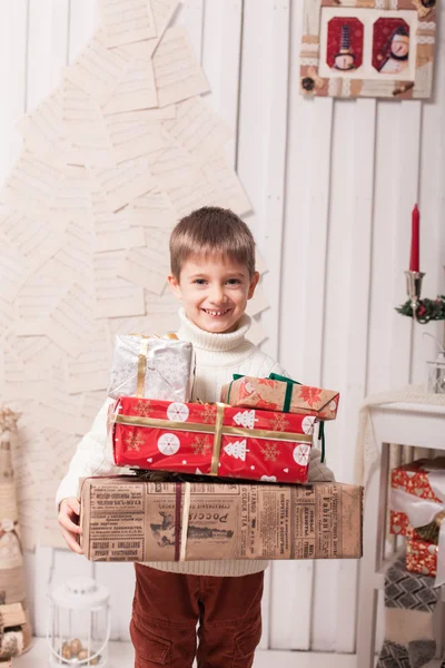 Kleiner Junge hält Geschenkbox im Weihnachtsinterieur — Stockfoto