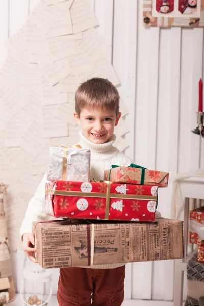 Little boy holding present box in Christmas interior — Stock Photo, Image