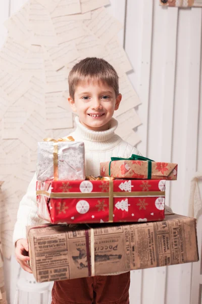 Kleiner Junge hält Geschenkbox im Weihnachtsinterieur — Stockfoto