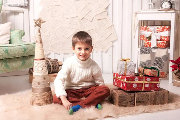 Little boy holding present box in Christmas interior — Stock Photo, Image