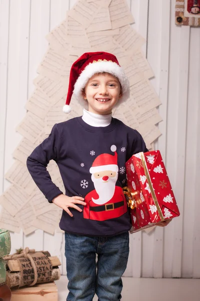 Kleiner Junge mit Geschenkbox im weihnachtlichen Interieur — Stockfoto