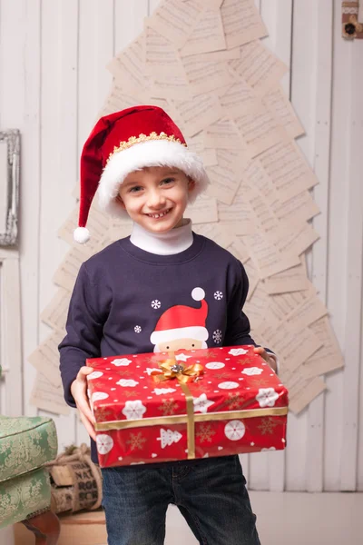 Kleiner Junge mit Geschenkbox im weihnachtlichen Interieur — Stockfoto
