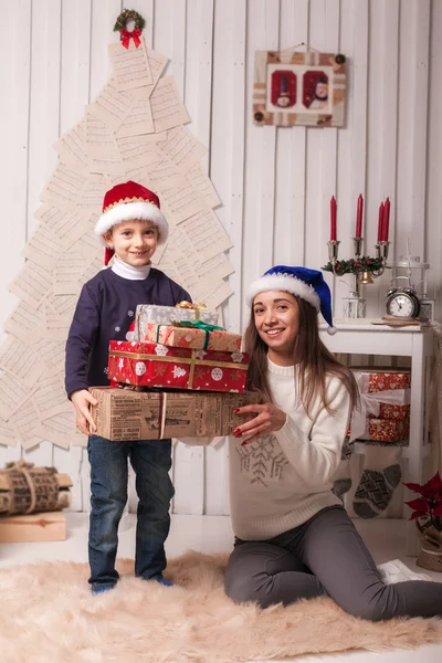 Kleine jongen met moeder poseren in Kerstmis interieur — Stockfoto