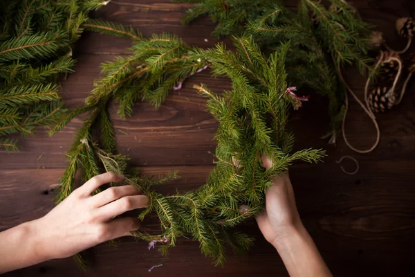 Ahşap arka plan üzerinde Noel çelenk el ile yapma