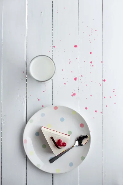 Witte cheesecake met rode bessen op een houten tafel. Stilleven — Stockfoto